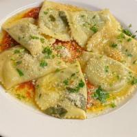 Mezzelune Di Ricotta · Homemade ravioli stuffed with spinach and ricotta cheese served over tomato sauce and topped...