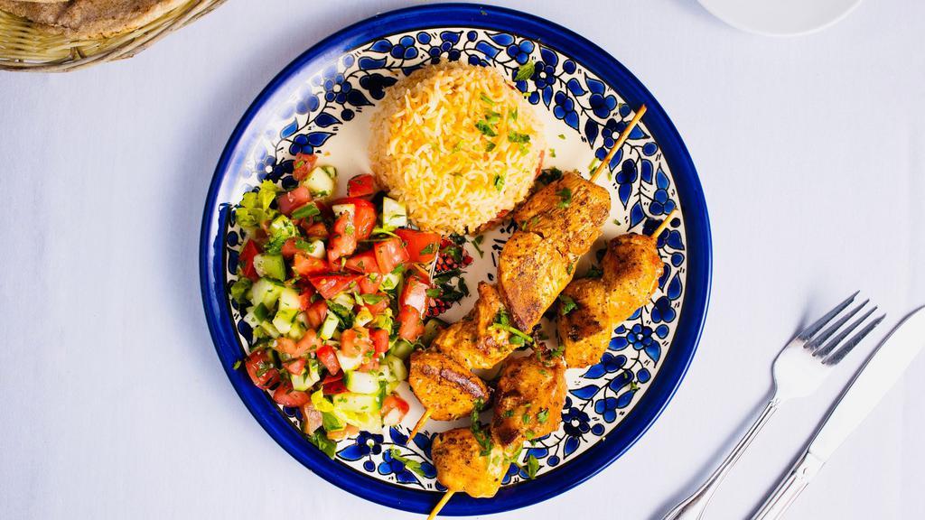 Chivalrous Chicken Bowl · Skewered pieces of chicken breast marinated in a Mediterranean blend of herbs and spices served with yellow rice and mixed vegetables.