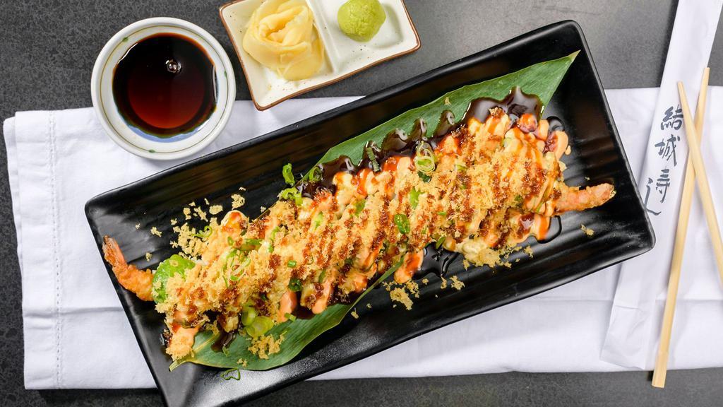 Tetsu (8) · two pieces of shrimp tempura, spicy tuna, and kani wrapped in avocado and topped with spicy sauce, crunch and green onions