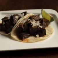 Carne Asada Tacos · Two Grilled Beef Tacos Topped with Onions and Morita Salsa.  Our Tacos are Served on House-M...