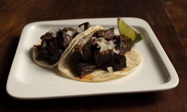 Carne Asada Tacos · Two Grilled Beef Tacos Topped with Onions and Morita Salsa.  Our Tacos are Served on House-Made Corn Tortillas