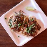 Carnitas Tacos · Two Slow Roasted Pork Tacos with Grilled Onions, Topped Tomatillo & Arbol Salsa and Cilantro...