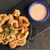 Chicharrones · Fried pork rinds with a side of spicy house sauce.
