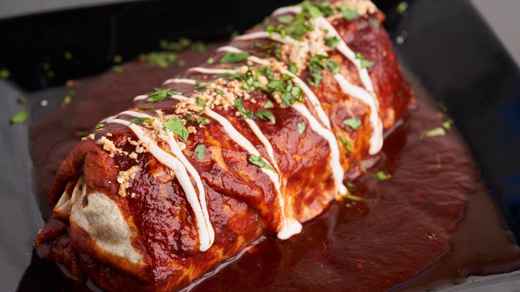 Wet Burrito (Pork Belly) · Spanish Rice With Cheese and Pork Belly, Rolled Into a Flour Tortilla and Smothered In Red Sauce. Topped With Tequila Sour Cream and Cotija Cheese.