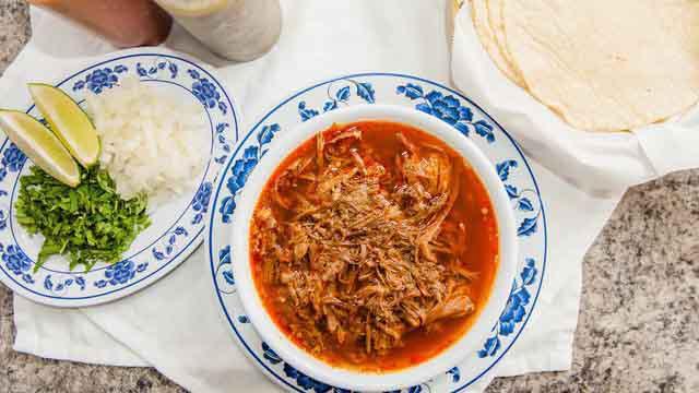 Birria · Goat stew (32 oz) in a hearty red broth. Served with your choice of tortillas, fresh onions, cilantro, limes, red and green salsa to prepare to taste.