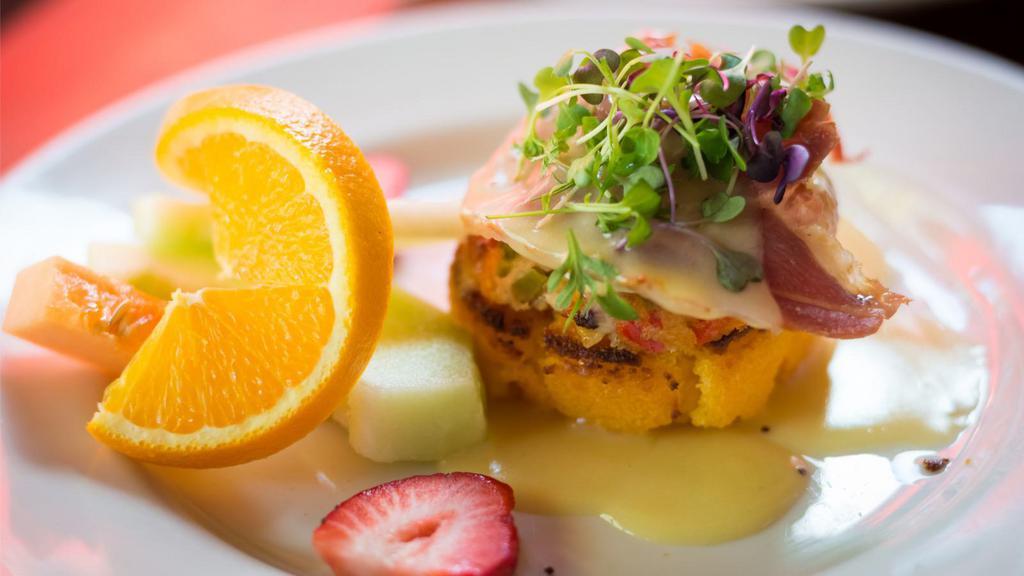 Crab Cake Benedict · Two crab cakes topped with avocado, poached eggs, and hollandaise sauce.