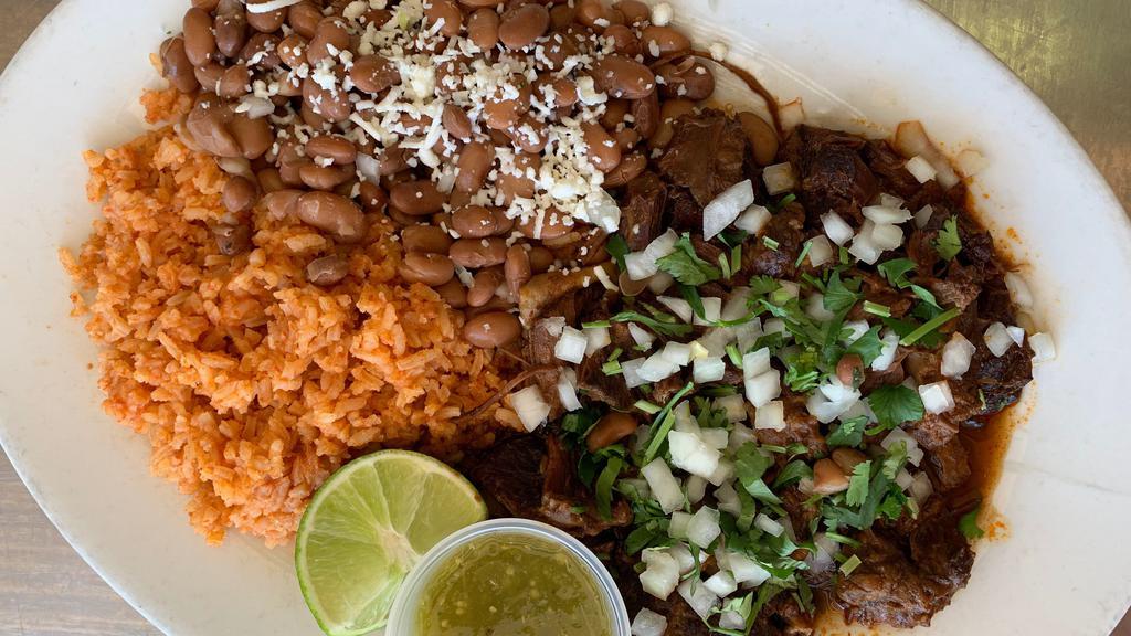 Birria plate with consome. · Birria topped with onions and cilantro, Mexican tomato rice, beans, choice of tortillas. Consome on the side.