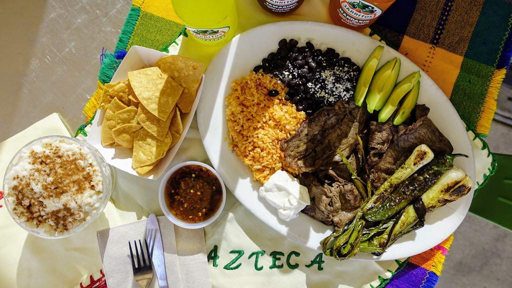 Carne Asada Plate · Fire grill Carne Asada. Choice of tortillas. Choice of beans, tomato rice, sour cream, grilled Jalapenos, grilled Mexican onions, Queso Fresco and sliced avocado.
