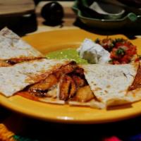 Quesadilla - Grilled flour tortilla stuffed with meat. · Choice of meat. Serve with sour cream, guacamole, and salsa fresca.