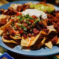 Nachos - Fresh organic corn chips. · Choice of meat. Topped with jack cheese, sour cream, refried beans, guac, salsa fresca, and ...