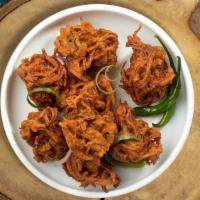 Over The Onion Pakora · Our special onions fried in a chickpea batter. Served with sliced onions & coconut chutney.