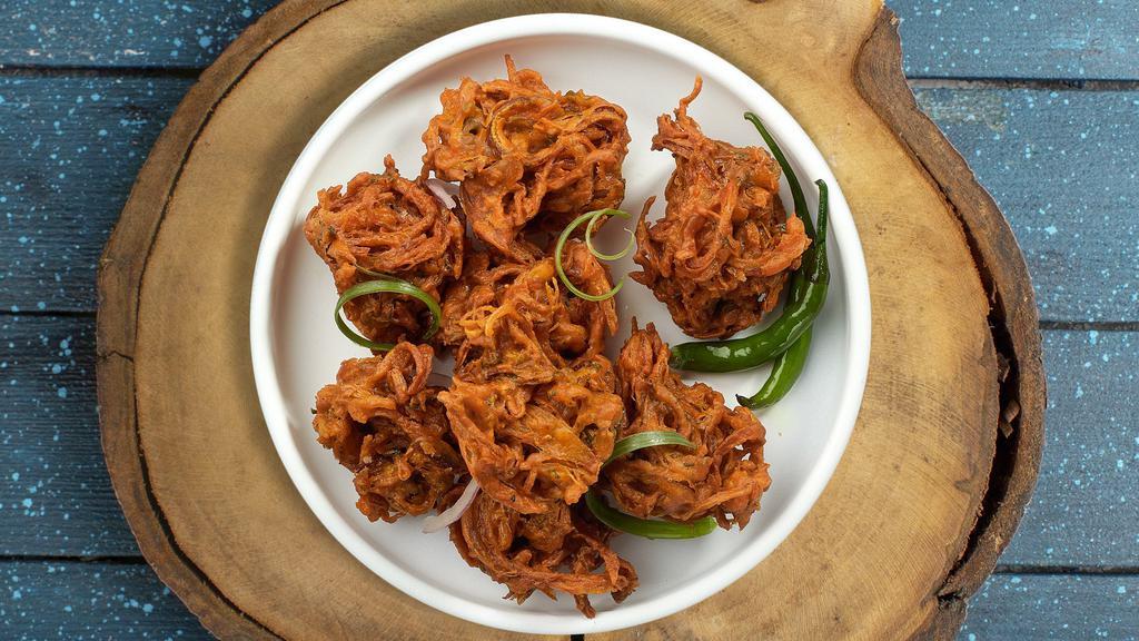 Over The Onion Pakora · Our special onions fried in a chickpea batter. Served with sliced onions & coconut chutney.