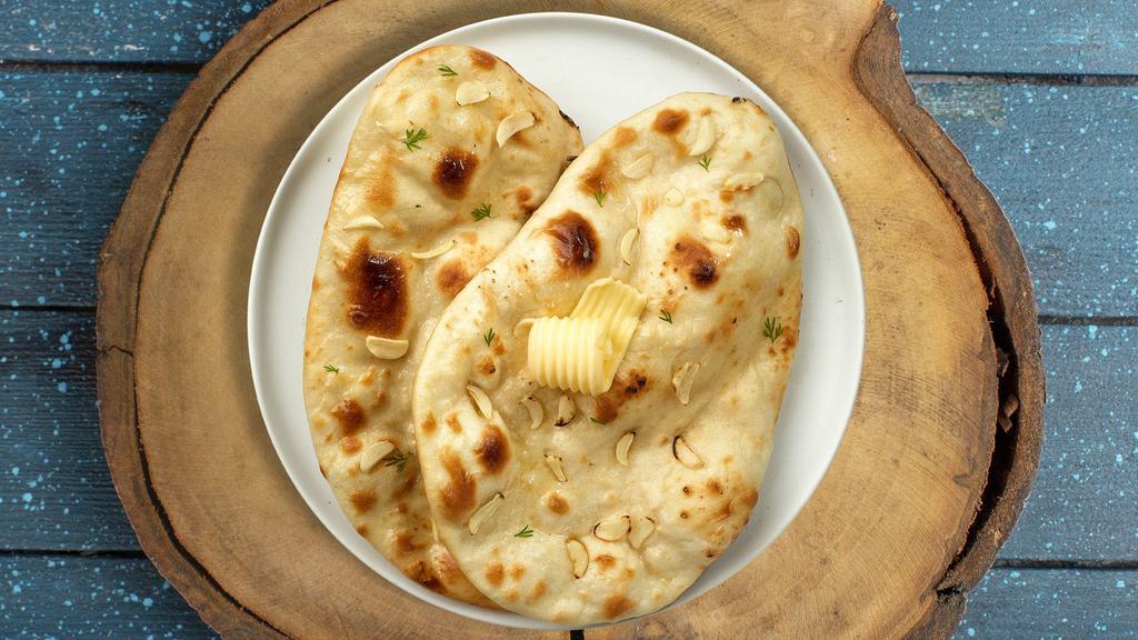 Garlic Chili Naan · Freshly baked bread in a clay oven garnished with garlic and butter