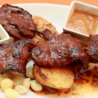 Anticuchos · Perfectly marinated beef heart pieces grilled in a special house marinade serve with Peruvia...