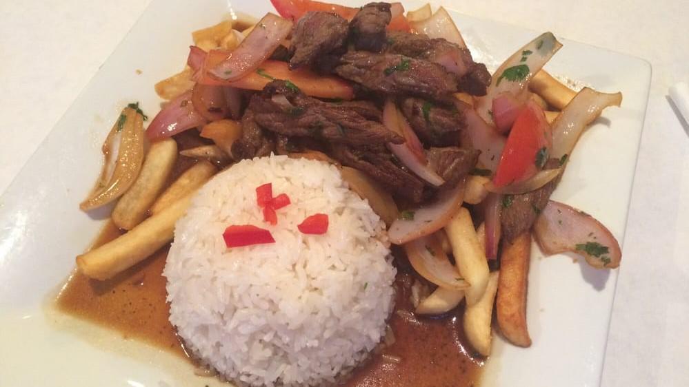 Lomo Saltado · Top sirloin strips saute with onions, tomatoes and a hint of vinegar and sillao (Peruvian soy sauce) served with steamed white rice and French fries.