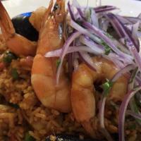 Arroz con Mariscos · Peruvian paella (rice, shrimp, calamari, mussels, aji panca, spices and herbs) served with s...