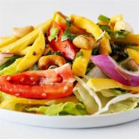 Mango Salad · Mango, red onion, roasted coconut, cashew nuts, and tomatoes in a Thai style dressing.