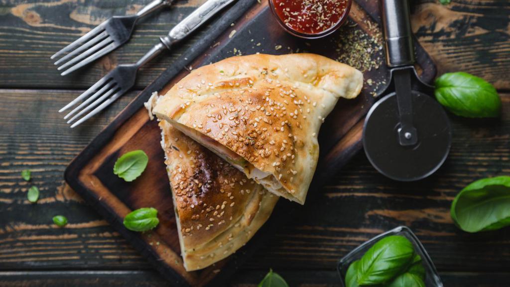 The Burrata Garlic Pesto Calzone · Delicious and freshly cooked calzone with mozzarella, ricotta, impossible meat, garlic and mushrooms.
