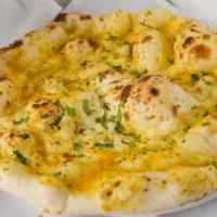 Garlic / Onion Naan · Indian flat bread made with refined flour and crushed garlic, baked in a clay pot.