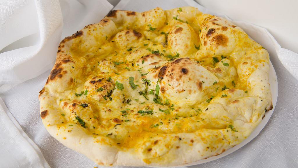 Garlic Naan · Leavened bread made in tandoor oven is topped with minced garlic.