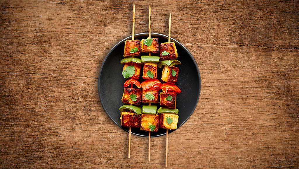 Charred Chicken Tikka · Boneless chunks of chicken marinated in herbs and spices barbecued in a clay oven on a skewer.