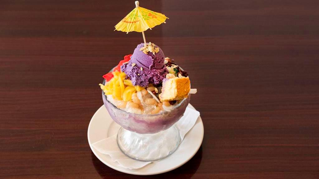 Halo Halo · Contain egg, dairy. A blend of refreshing tropical fruit preserves, beans and milk in shaved ice. Topped with a delicious scoop of ube (purple yam) ice cream, flan and rice flakes. A classic Filipino dessert.