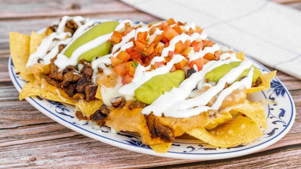 Nachos · Tortilla chips served with melted cheese, choice of beans, guacamole, sour cream, and fresh salsa.