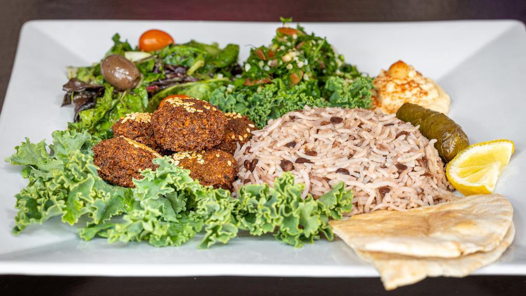 Greek Platter · Falafel with lentil rice, hummus, tabbouleh, cucumber salad, greek salad, dolma, and pita bread kofta platter.