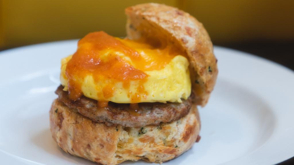 Sausage Biscuit · Scrambled egg, sausage, cheddar cheese, and tomato jam on cheddar chive biscuit.