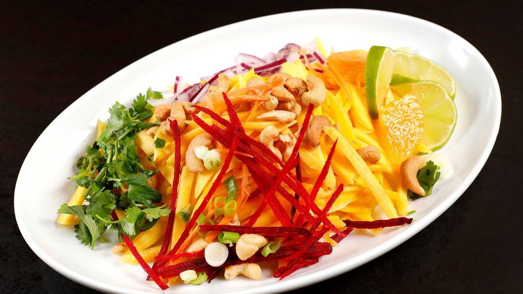Green Mango Salad · Shredded green mango seasoned with onions, green onions, cilantro, cashew nuts, and grilled shrimps in light lime dressing.