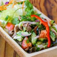 Yum Nua · Grilled slices beef with lemongrass, onions, mint, cucumber, tomato, cilantro, roasted rice ...