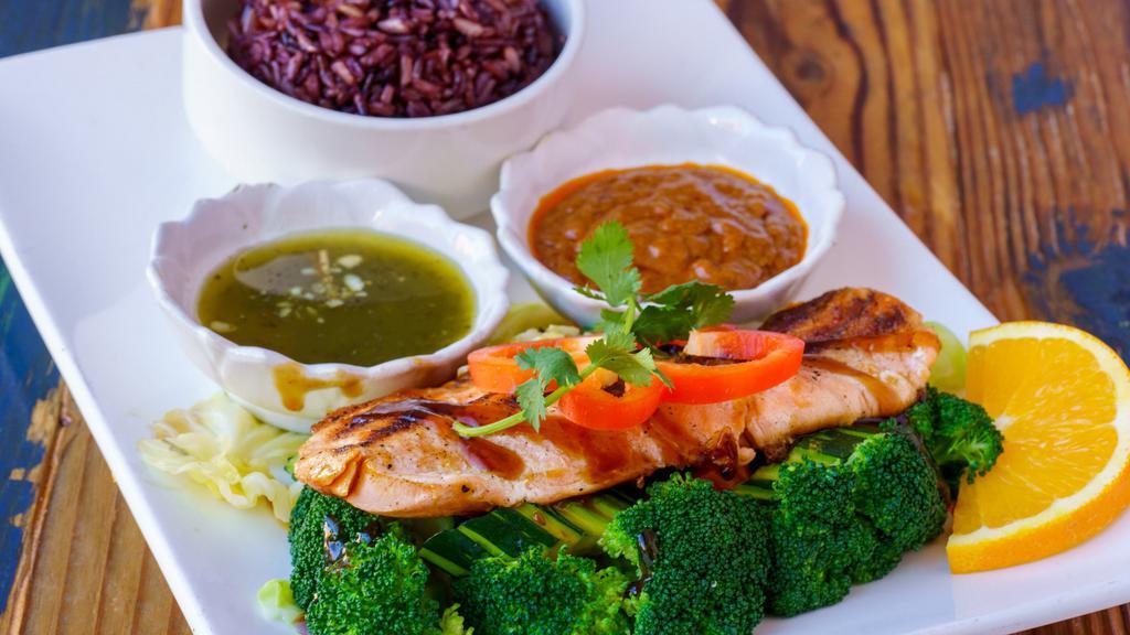 Grilled Salmon · Grilled marinated salmon with Thai spices & herbs served with Thai hot sauce, peanut sauce, steam vegetable, and brown rice.
