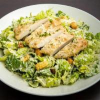 Chicken Caesar Salad · Lightly breaded chicken breast strips atop romaine lettuce tossed with Caesar dressing, shre...