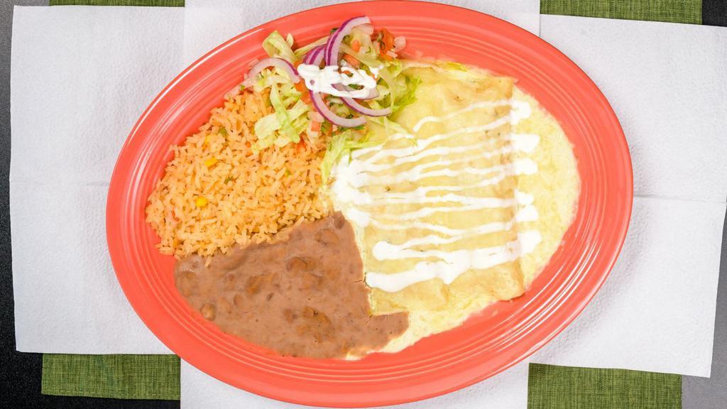 Enchiladas Suizas · Two chicken enchiladas topped with a cream-cheese green sauce, served with a side of rice and re-fried beans.