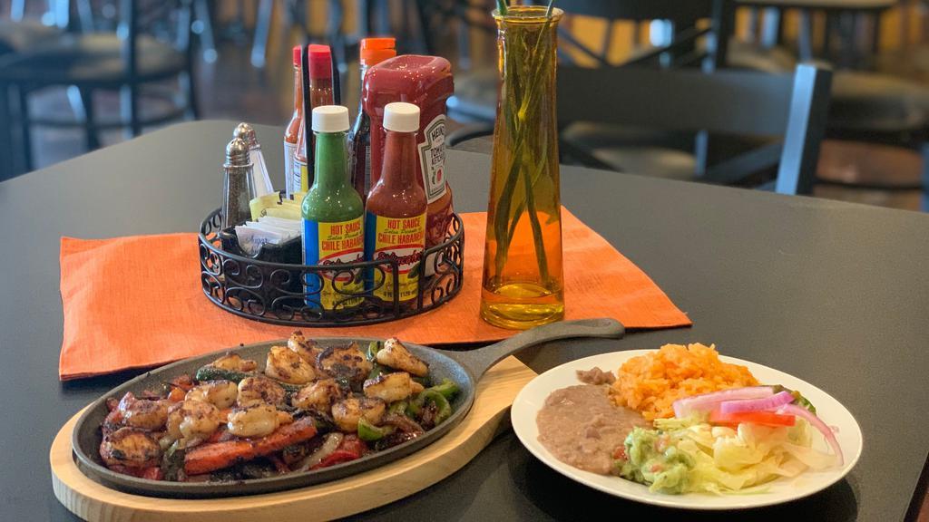 Fajitas De Camarón · Shrimp Fajitas with Grilled Onions, Bells Papers , Topped with Mozzarella Cheese,  served with Rice, Re-fried Beans, Salad and Fresh Guac.