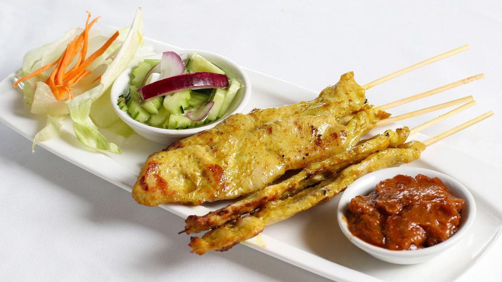 Chicken Satay · Five skewers. Marinted chicken on skewers served with peanut sauce and small cucumber salad.