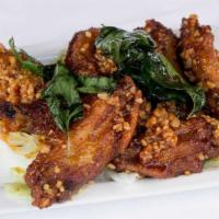 Angel Wings · Crispy chicken wings sautéed with chili garlic sauce with crispy basil leaves.