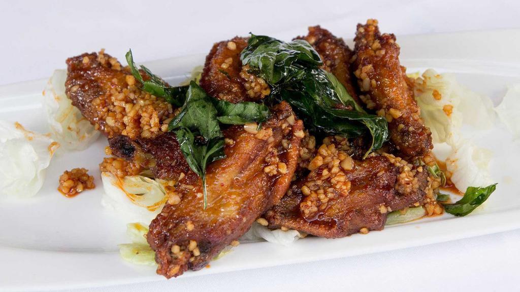 Angel Wings · Crispy chicken wings sautéed with chili garlic sauce with crispy basil leaves.