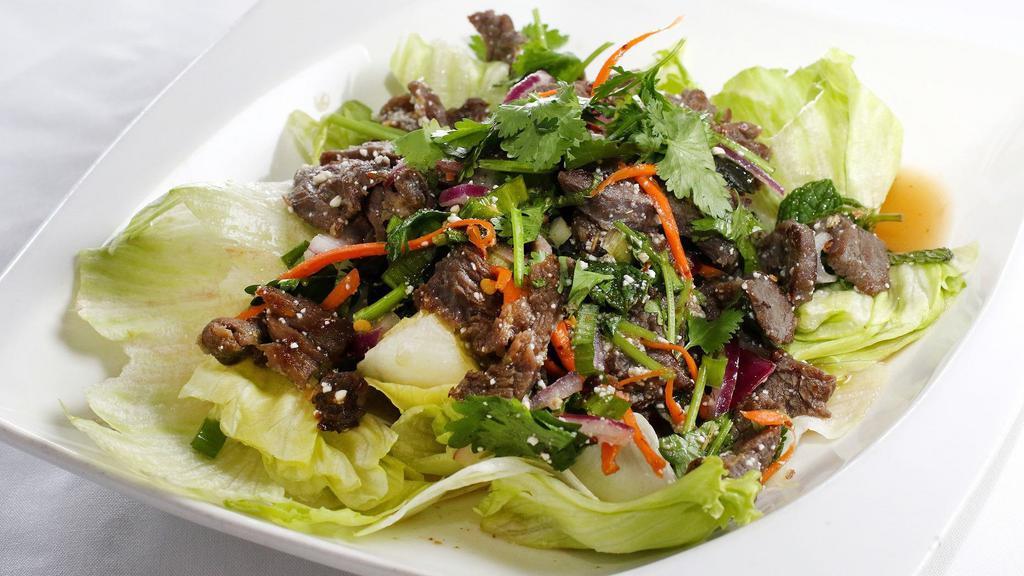 Nam Tok Salad · Choice of pork or beef. Grilled with mint leaves, onions, cilantro, roasted rice powder, and spicy lime dressing on a bed of lettuce.