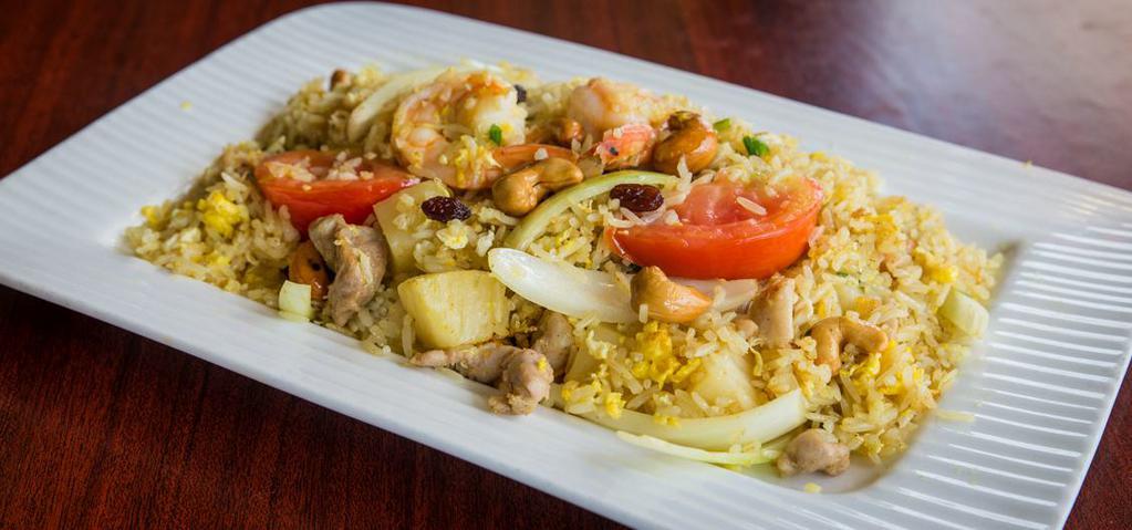 Pineapple Fried Rice · Steamed jasmine rice stir fried with egg, chicken, prawns, pineapple, onions, tomatoes, cashew nuts, and curry powder.