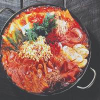 Budae Jjigae · Spicy stew with kimchi, ramen, spam, sausage, cheese, and tofu. Comes with two bowls of rice...