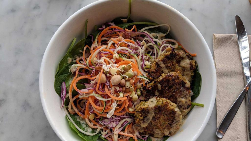Warrior Bowl · Spinach, carrots, cabbage, zucchini, sprouted beans, and avocado. Topped with the Nourish Burger (quinoa and black bean patty, gluten-free) with red pepper almond dressing.