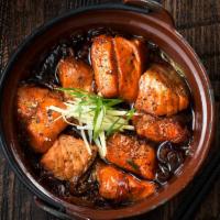 Iron Pot Salmon · Fresh salmon cubes, ginger, onion, and caramelized black pepper soy.