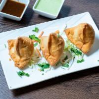 Samosa · Vegetable masala stuffed in a flaky pastry shell and deep fried.