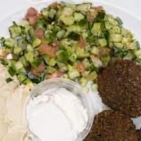 Falafel for Hummus · Eggplant, dolma, hummus, falafel and feta with tahini sauce served on a bed of hummus with l...