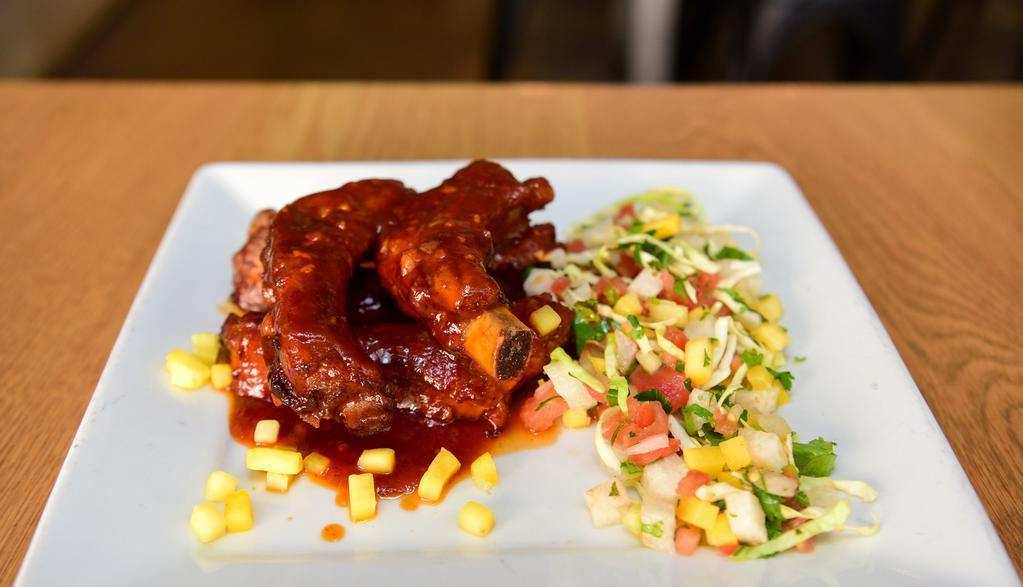 Baby Back Ribs · Tamarindo BBQ ribs served with mango and cabbage slaw