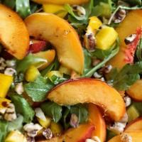 Arugula Peach Salad · Peaches, red pepper, fried beets, shredded goat cheese tossed in a grapefruit vinaigrette.