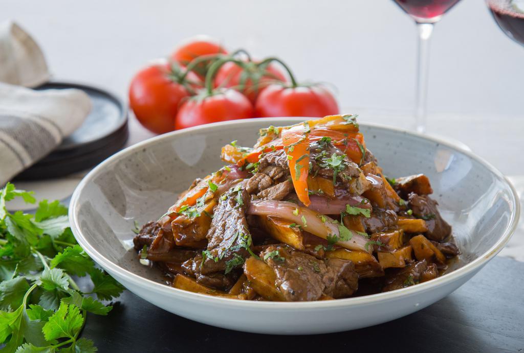 Lomo Saltado   · Beef tenderloin, red onion, tomato, shoyu, cilantro with a choice of rice/french fries or beans tacutacu