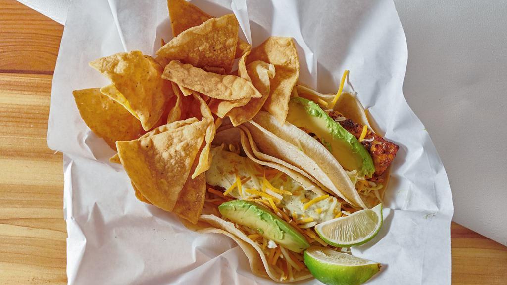 Baja Grilled Fish Tacos · Two soft corn tortilla tacos filled with grilled fish and crisp cabbage topped with baja sauce, avocado slices and jack and cheddar cheeses.