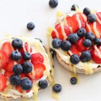 Blueberry Situation · Blueberry bagel, lemon cheesecake spread, sliced strawberries, and blueberries, and drizzled...